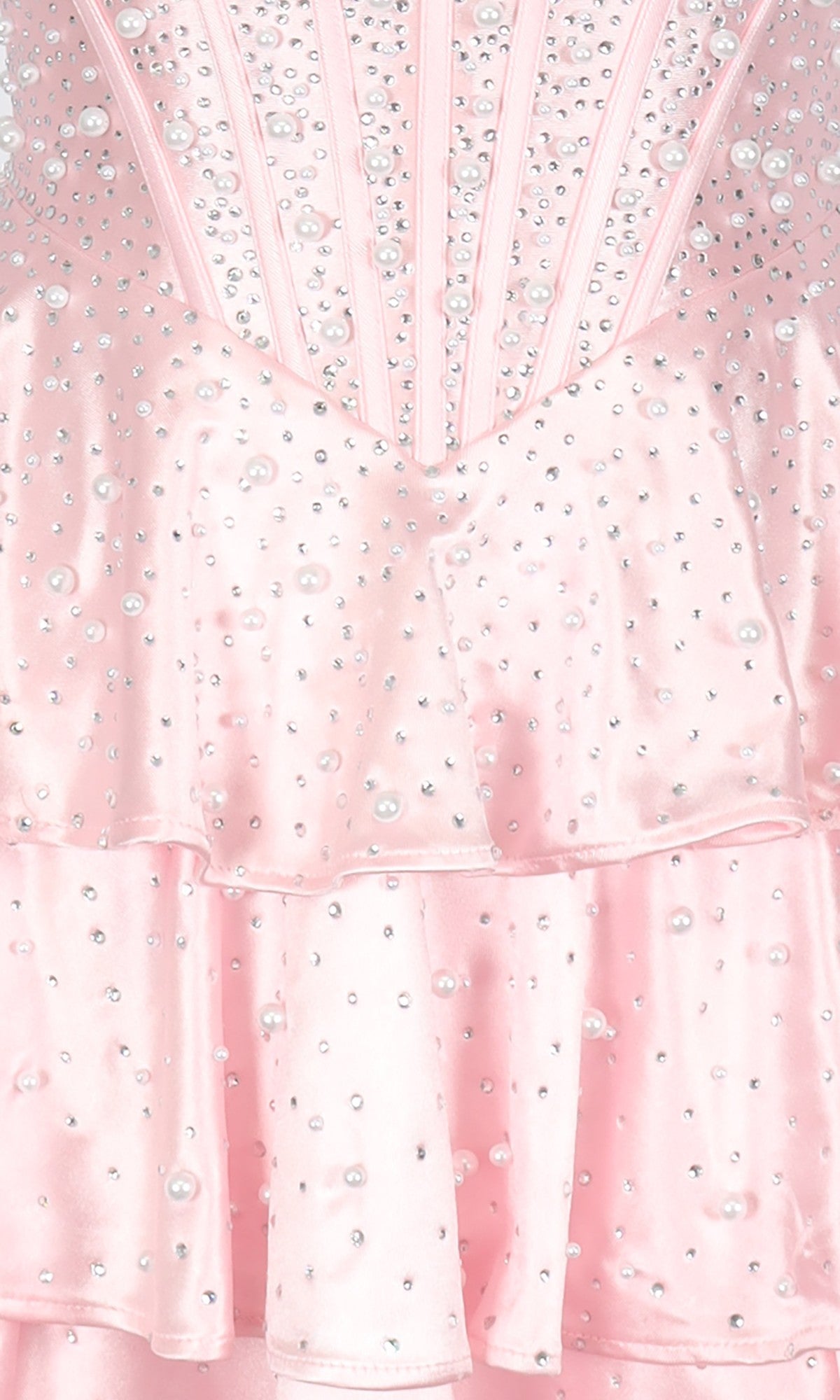 Close-up of the PromGirl Exclusive 250347 short homecoming dress, a light pink fit-and-flare style with satin-like layered fabric and small pearl embellishments.